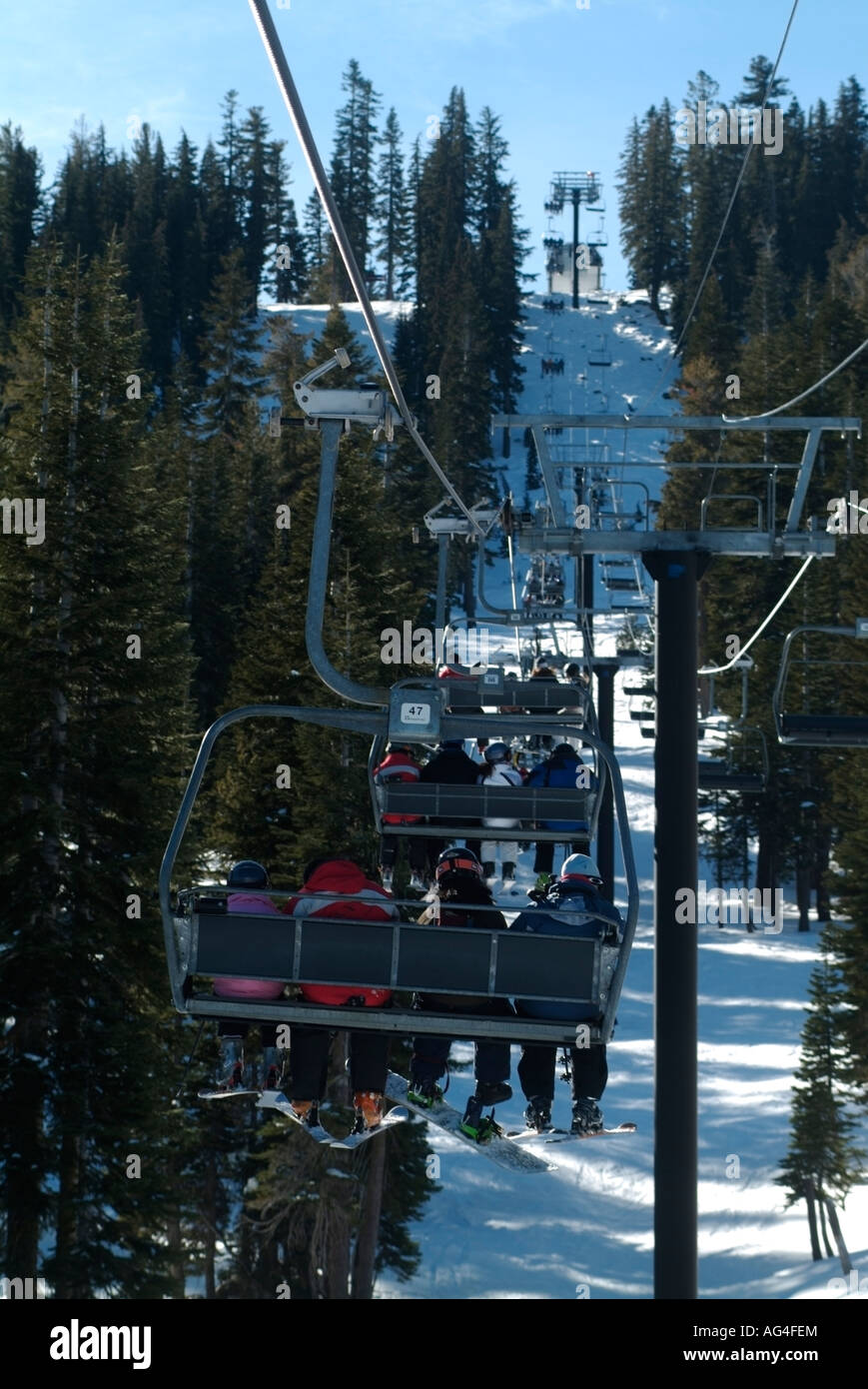 Alpinskifahrer und Snowboarder fahren die Sesselbahn in einem Skigebiet California über Lake Tahoe, Kalifornien Stockfoto