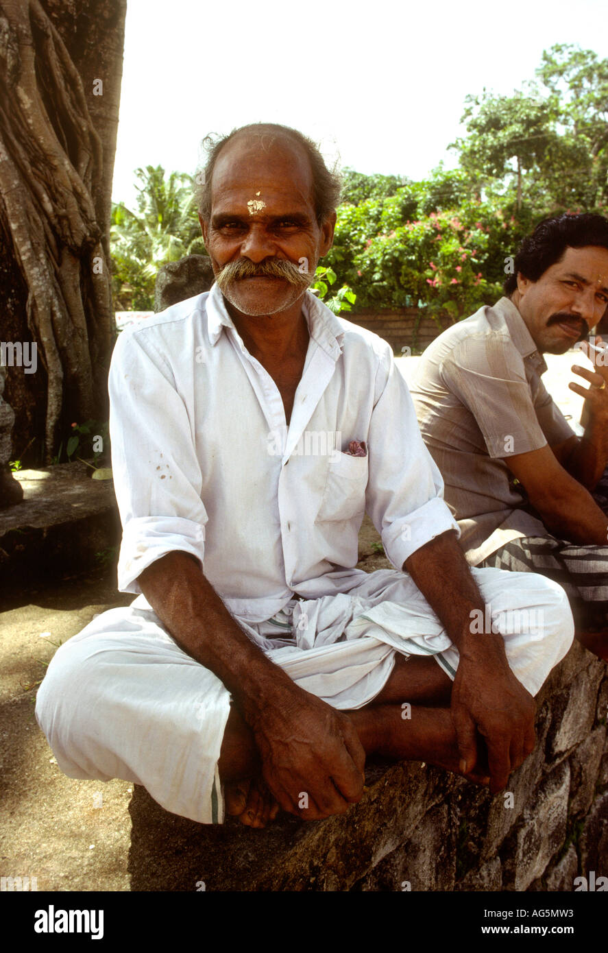 Indien-Kerala-Alleppey Religion Mann sitzt außerhalb Hindu-Tempel Stockfoto