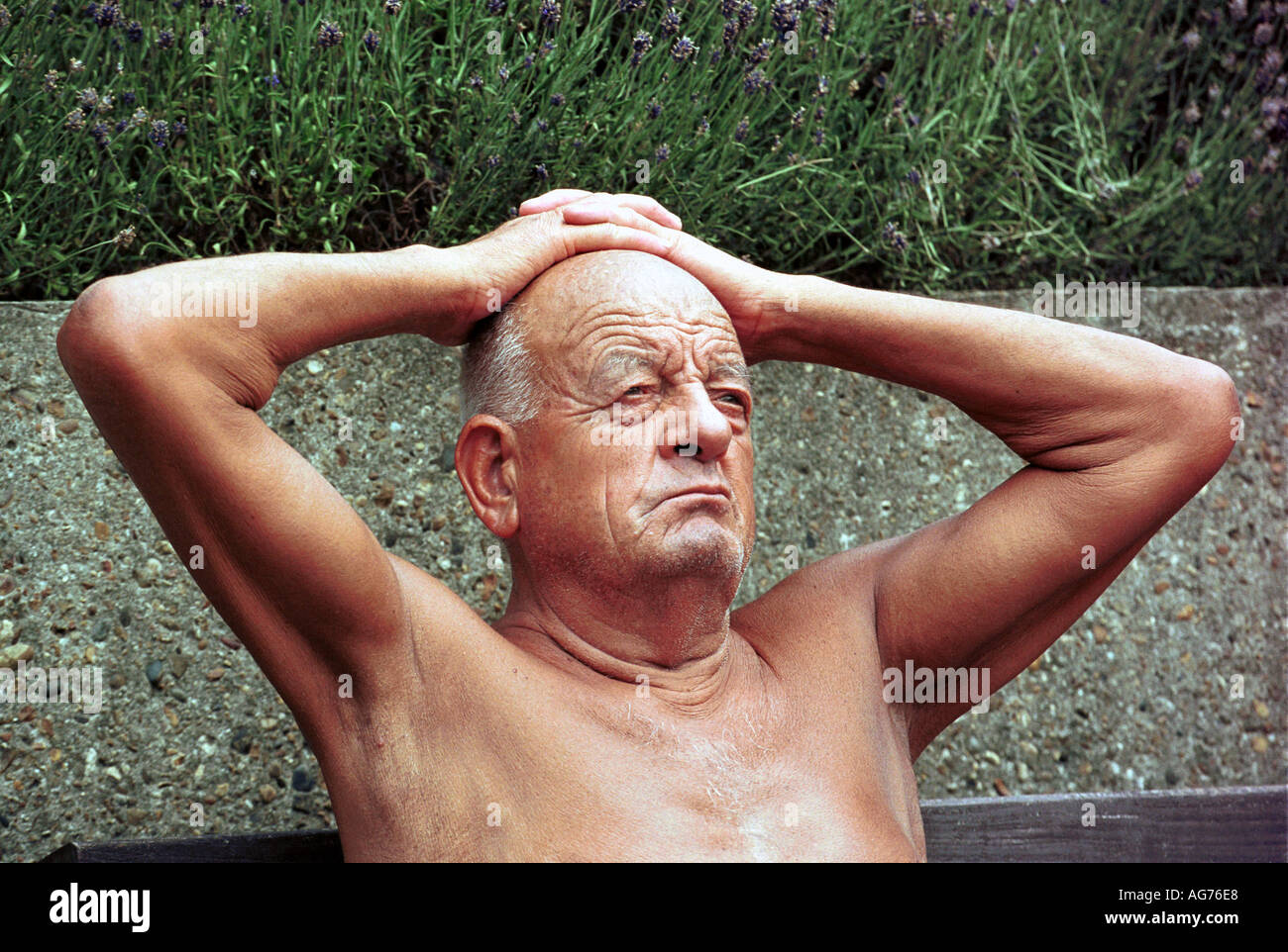 Mann mit Händen auf dem Kopf an einem heißen Sommertag in London Stockfoto