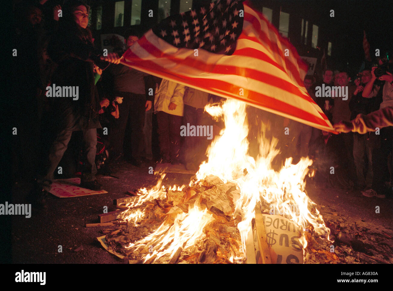 Menschen, die eine amerikanische Flagge in London brennen Stockfoto