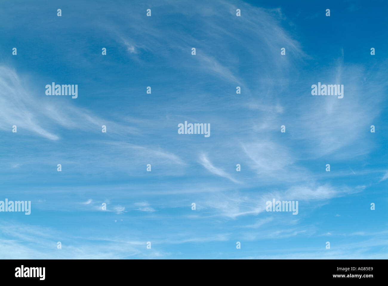 Blauer Himmel mit Wolkenfetzen Stockfoto