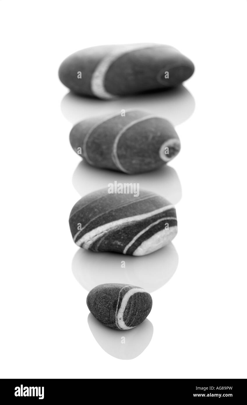 Vier Steinen mit verschiedenen Größen in DOF isoliert auf weißem Hintergrund Stockfoto