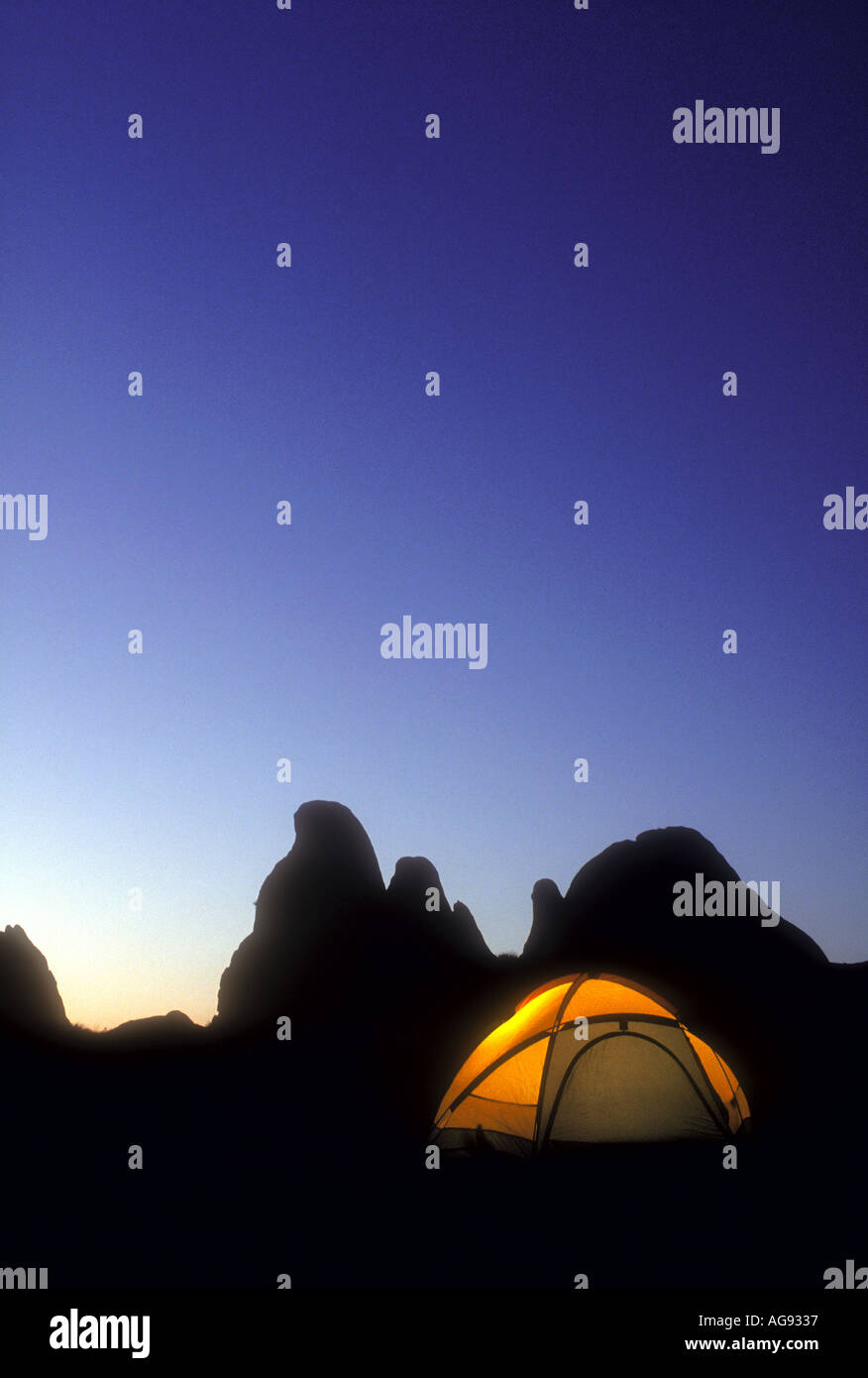 Glühende camping Zelt am frühen Abend mit Berggipfeln im Hintergrund Eigenschaft veröffentlichte Bild Stockfoto