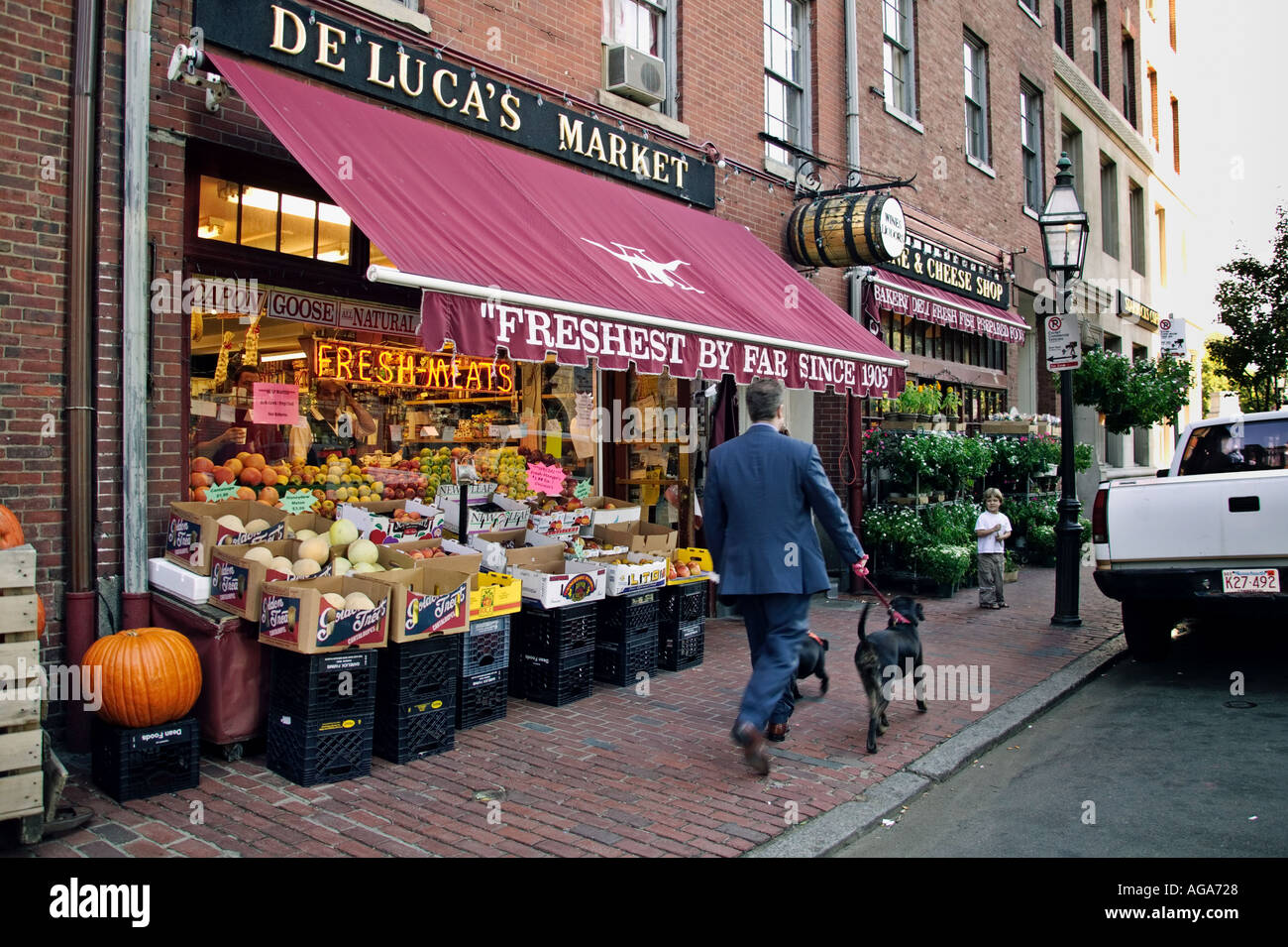 Mann mit Hund geht vorbei an De Lucas Market und Deli in der Charles Street am Beacon Hill Boston MA Stockfoto