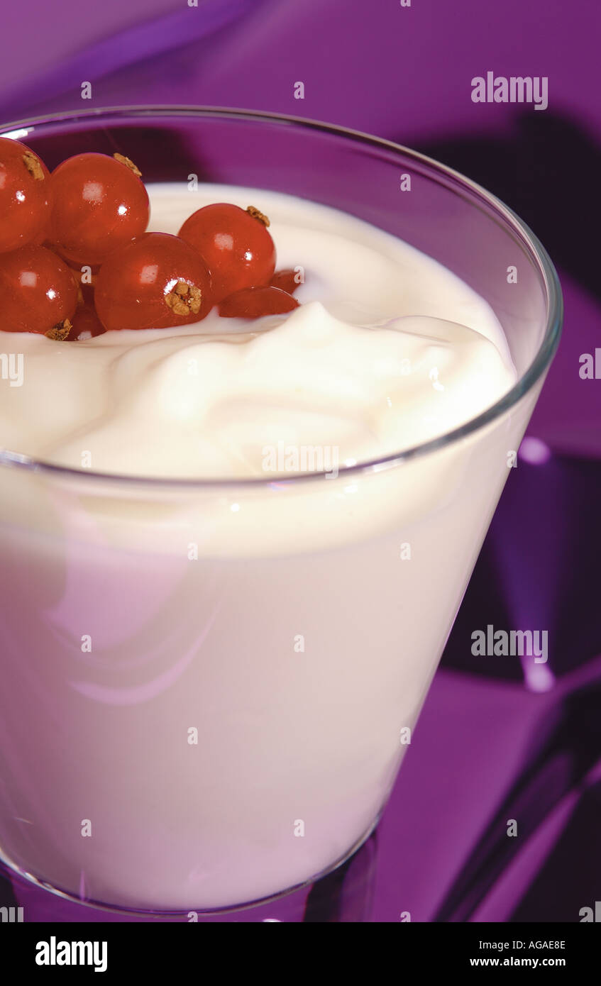 Nahaufnahme von frischen roten Johannisbeeren in einem Glas Joghurt Stockfoto