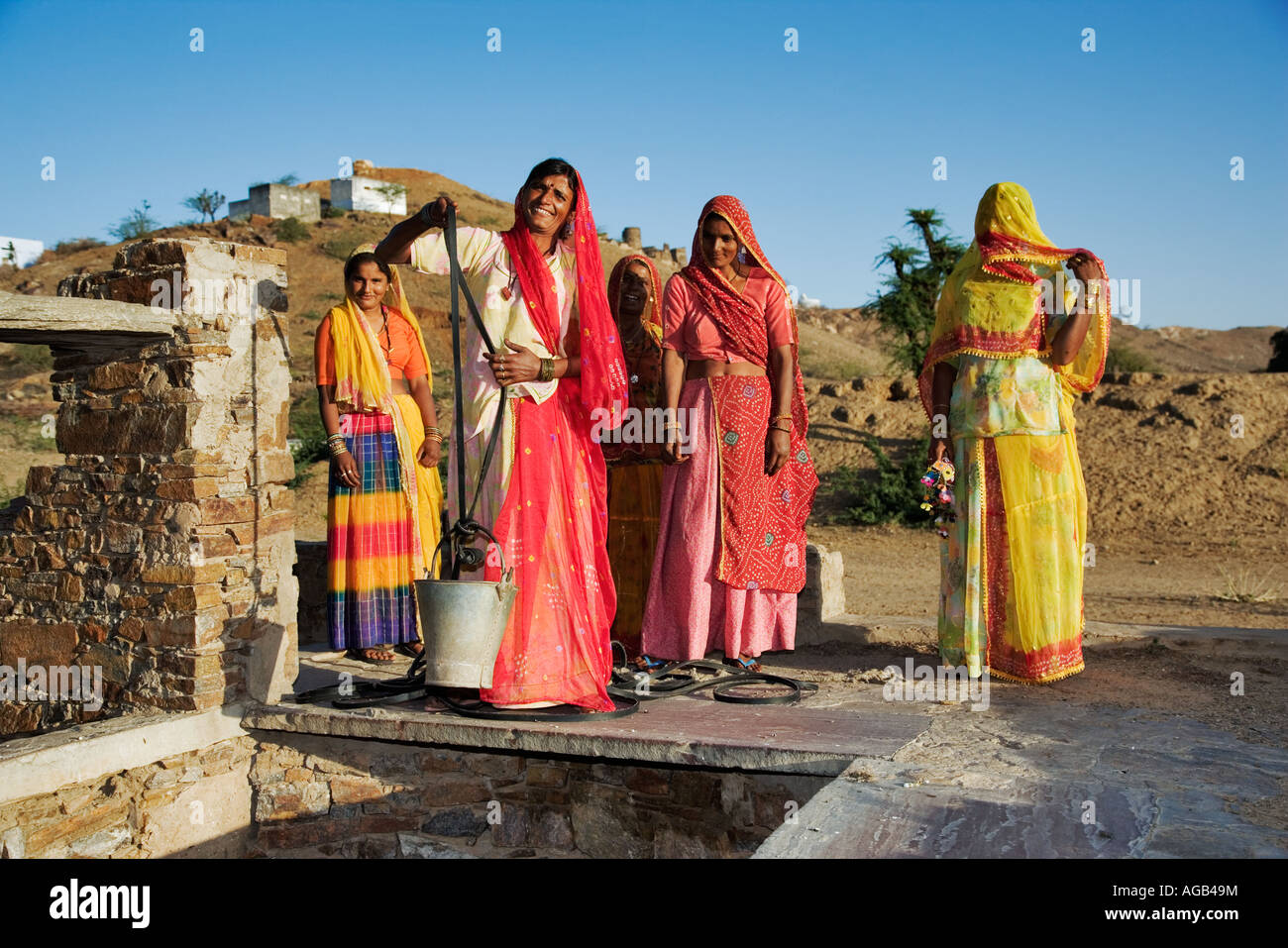 Frauen ziehen Wasser aus einem Brunnen außerhalb Pushkar Indien Modelle veröffentlicht Stockfoto
