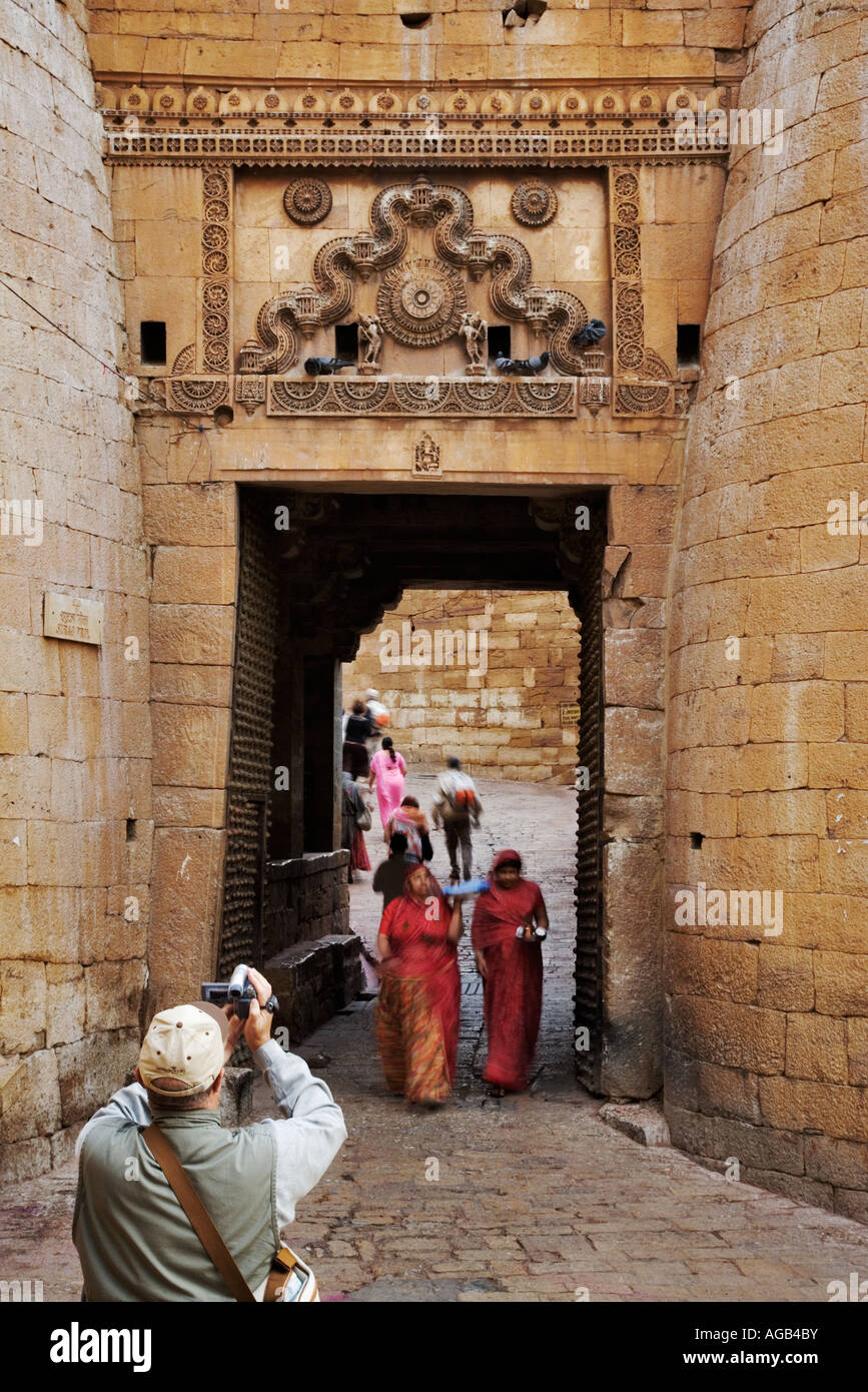 Sun gate Jaisalmer Fort Frauen mit Tor auf dem Weg zum Tempel Laxmi für den morgendlichen Gottesdienst von Touristen fotografiert Stockfoto