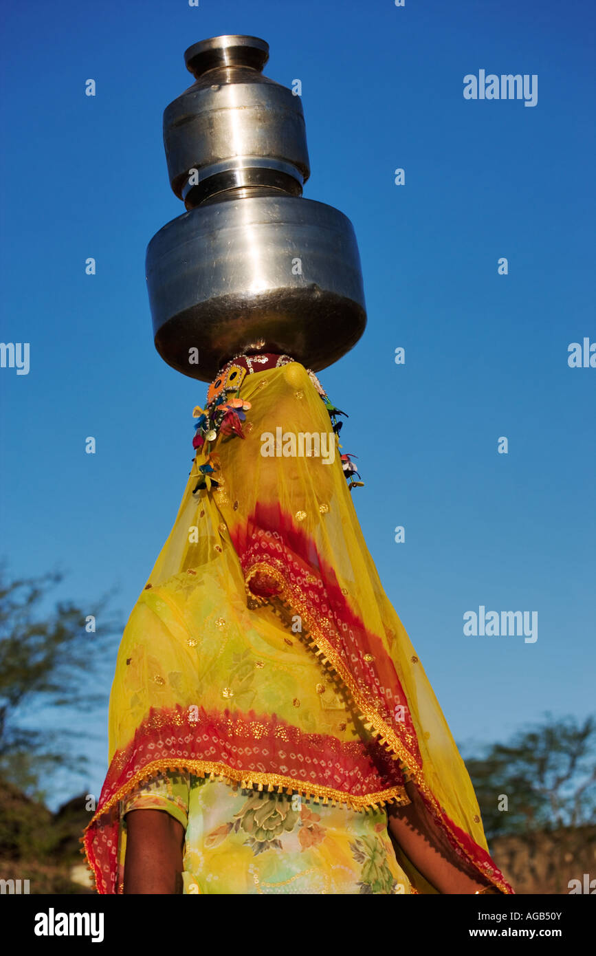 Frau Wassertragen auf traditionelle Weise aus einem Brunnen außerhalb Pushkar Indien Modell veröffentlicht Stockfoto