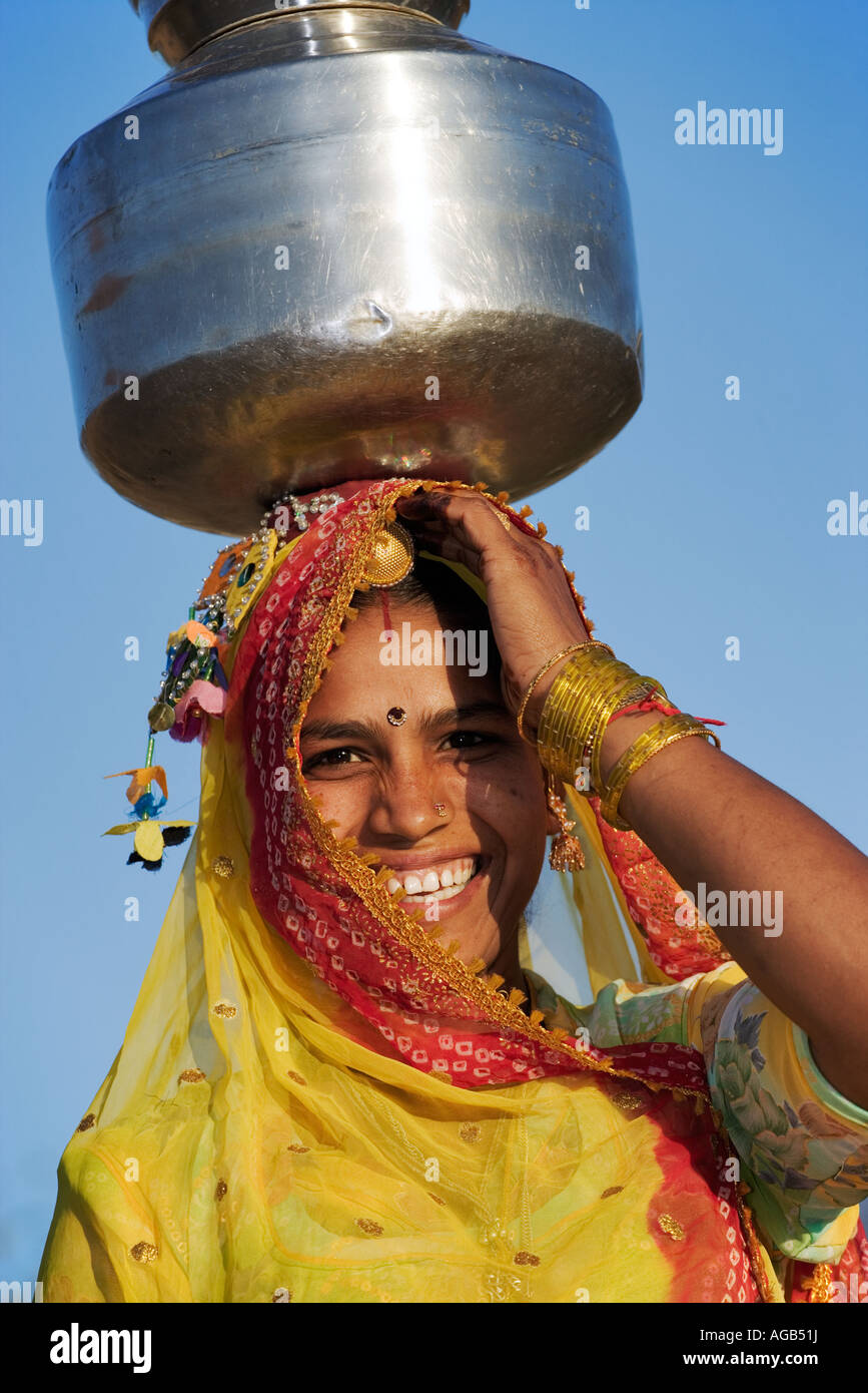 Frau Wassertragen auf traditionelle Weise aus einem Brunnen außerhalb Pushkar Indien Modell veröffentlicht Stockfoto