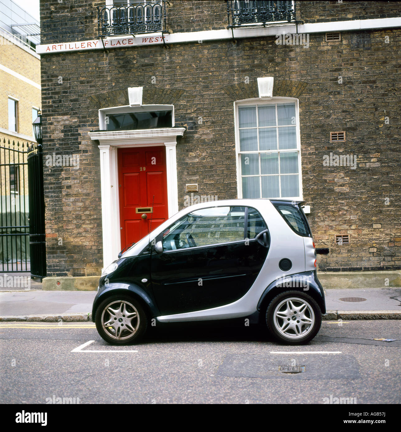 Ein Smart Auto ausserhalb einen Stein geparkt Reihenhaus mit einem roten Tür auf Artillerie Zeile West, Bunhill Row, Finsbury, London EC 1, England UK KATHY DEWITT Stockfoto