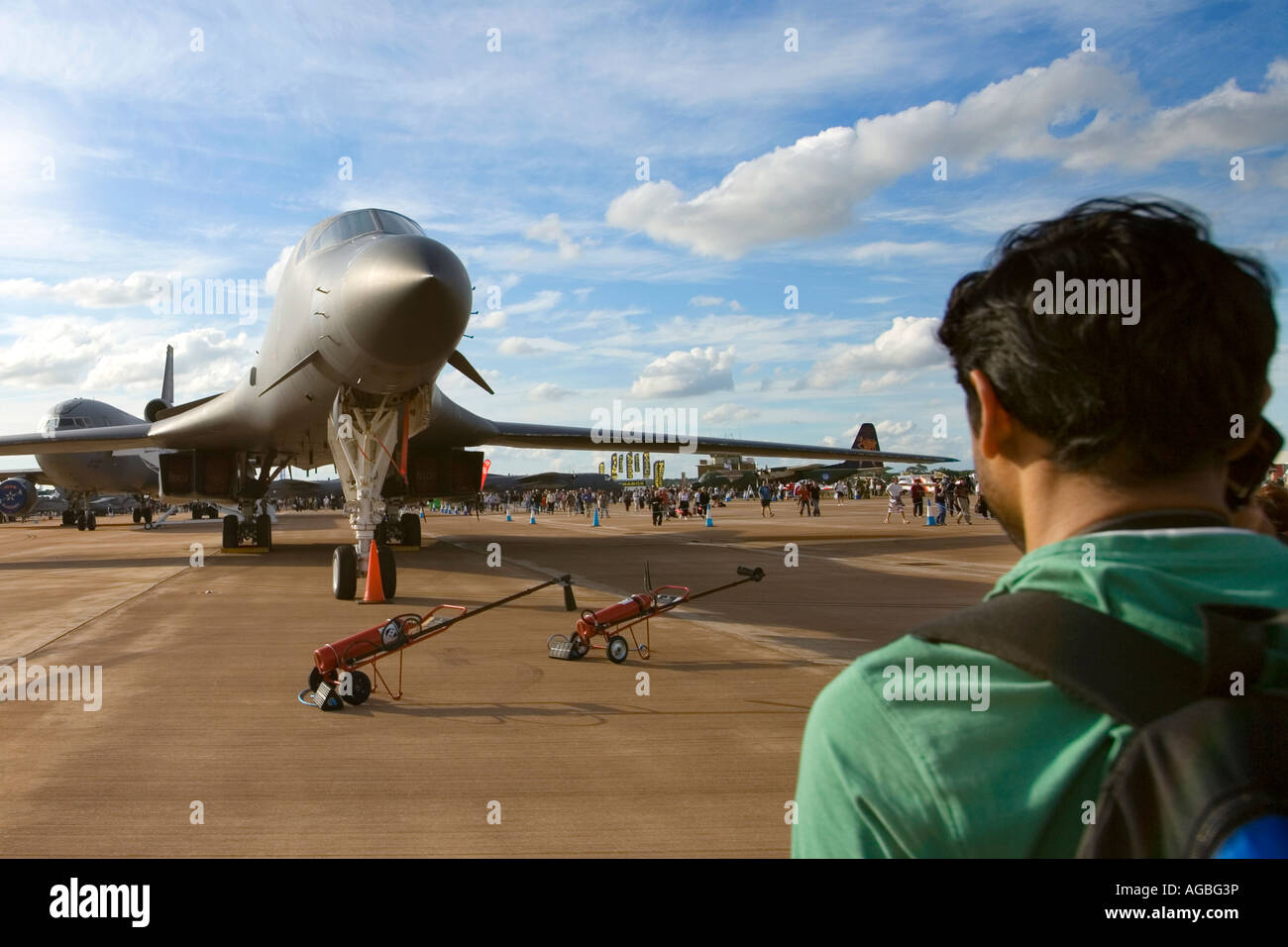 USAF Airforce B1-B Lancer Bomber Flugzeug abgestellt in Sonnenschein, blauen Himmel, während jungen asiatischer Mann im grünen T-shirt sieht auf Stockfoto