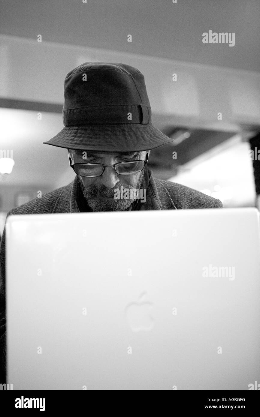 Alter Mann im Pub mit Apple Mac laptop Stockfoto
