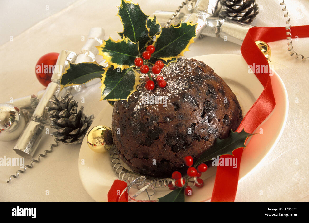 Christmas Pudding mit Holly auf weißen Teller dekoriert Stockfoto