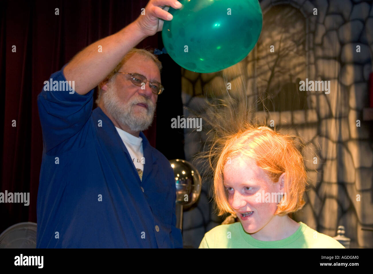 Ein Mann zeigt statische Elektrizität mit einem Ballon und die Haare des Mädchens im Discovery Center in Little Rock, Arkansas. Stockfoto