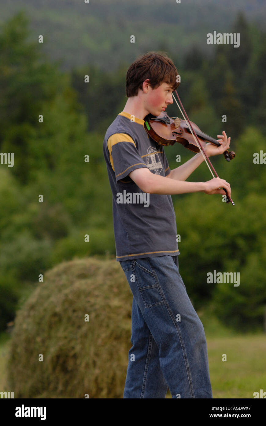 Stock Bild eines jungen Mannes, spielt die Geige oder Violine in einem Land-Bauernhof Stockfoto