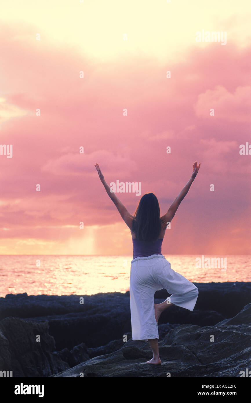 Frau in Yogaposition bei Sonnenuntergang Stockfoto