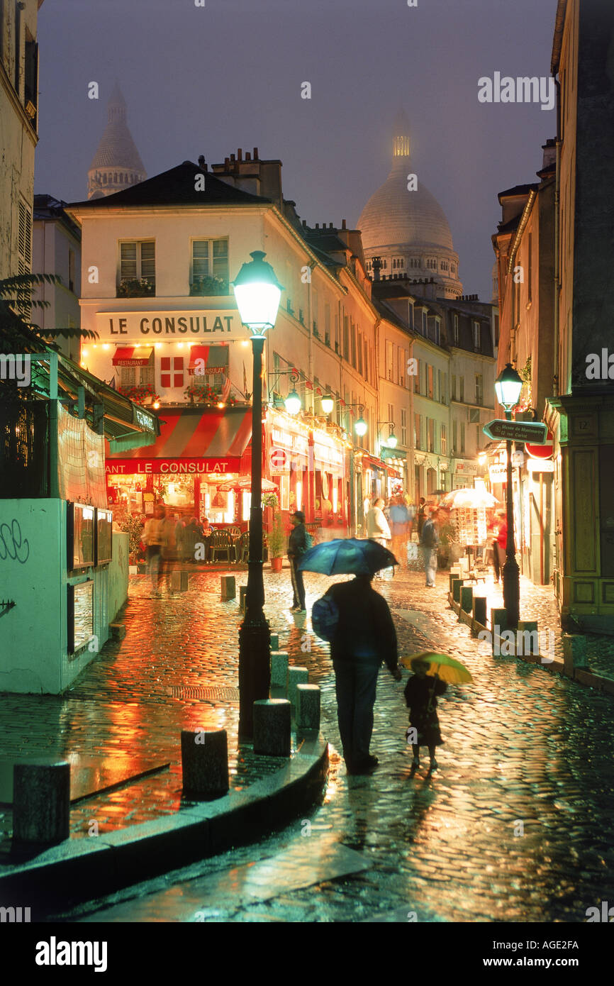 Vater und Tochter zu Fuß nass gepflasterten Straßen von Montmartre im Regen in der Nacht in Paris Stockfoto