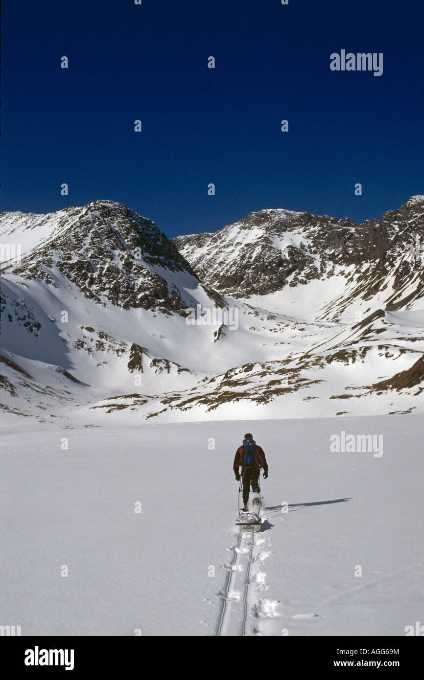 Mann Schneeschuhwandern Crow Pass Chugach Mtns Yunan AK verfolgt Schnee Winter Stockfoto