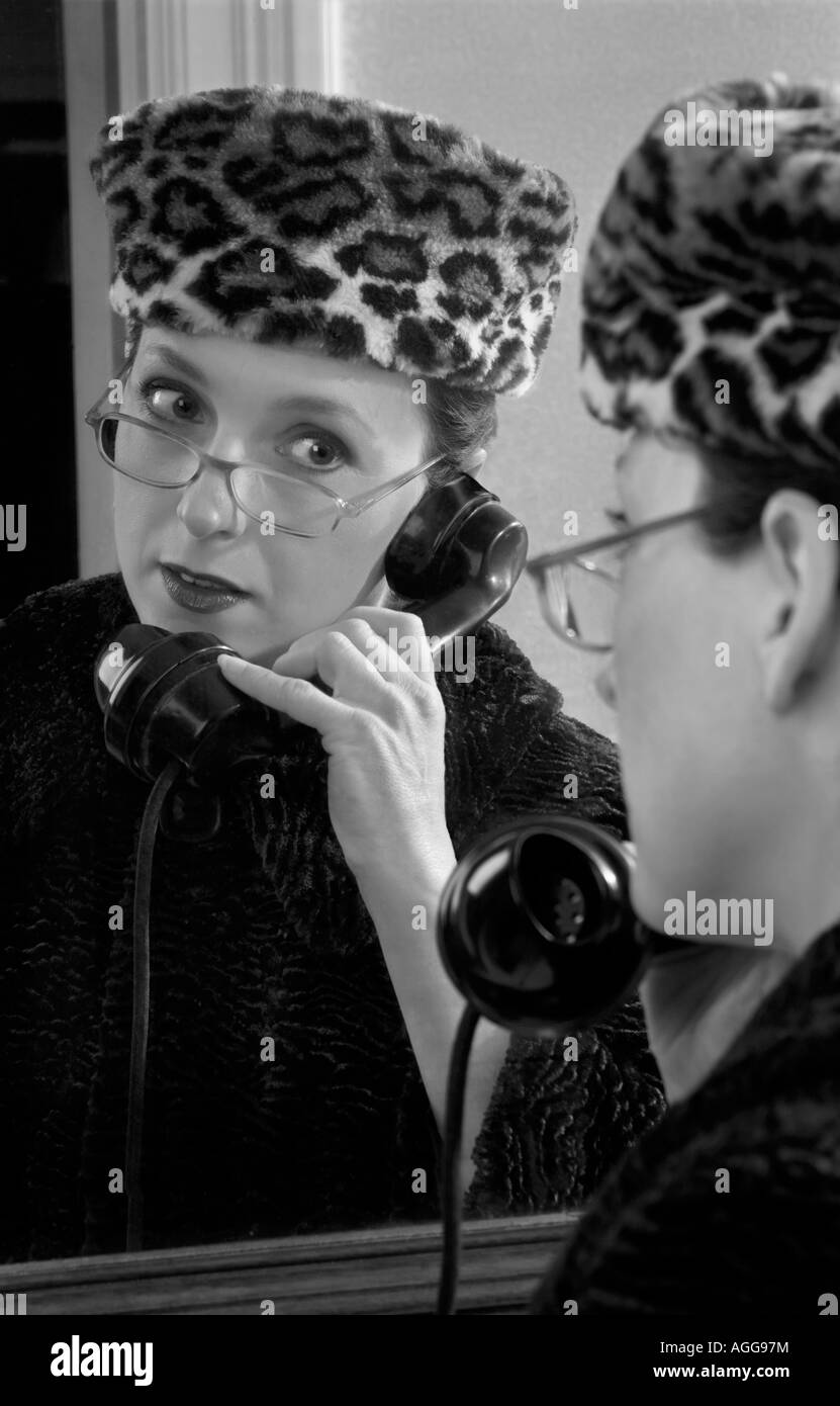 Frau spricht über alte altmodische 1950 s Telefon im Stil des Fotografen Norman Parkinson Stockfoto