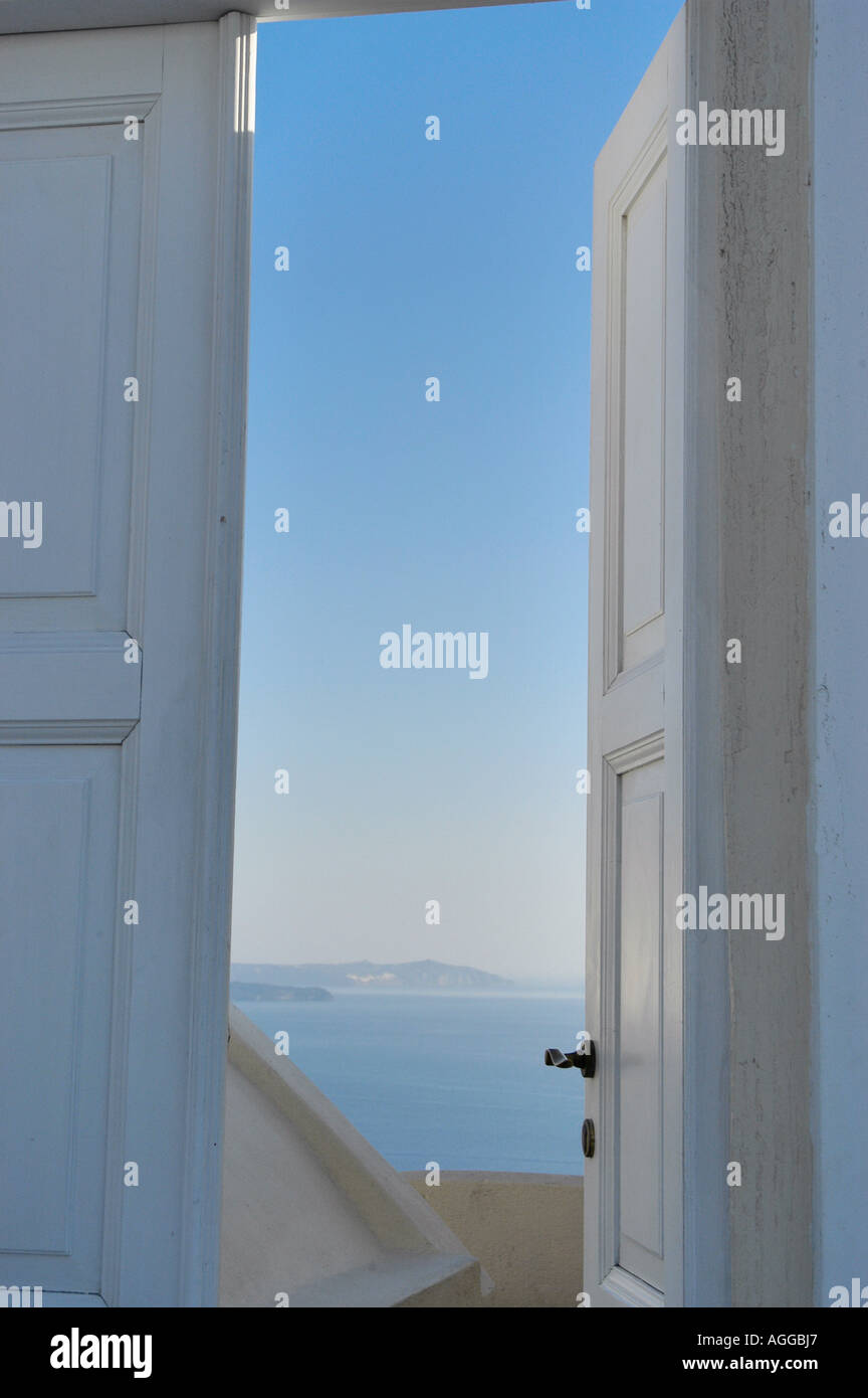 leicht geöffneter Tür mit blauem Himmel hinter Dorf Oia, Santorin, Griechenland Stockfoto