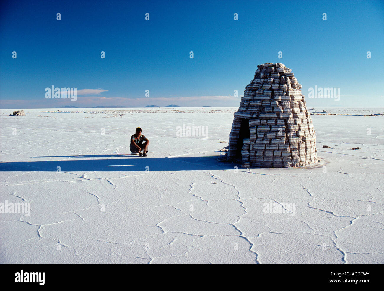 Bolivien, Uyuni, Mann sitzt von Iglu machte der Salzziegel in Uyuni Salzsee Stockfoto