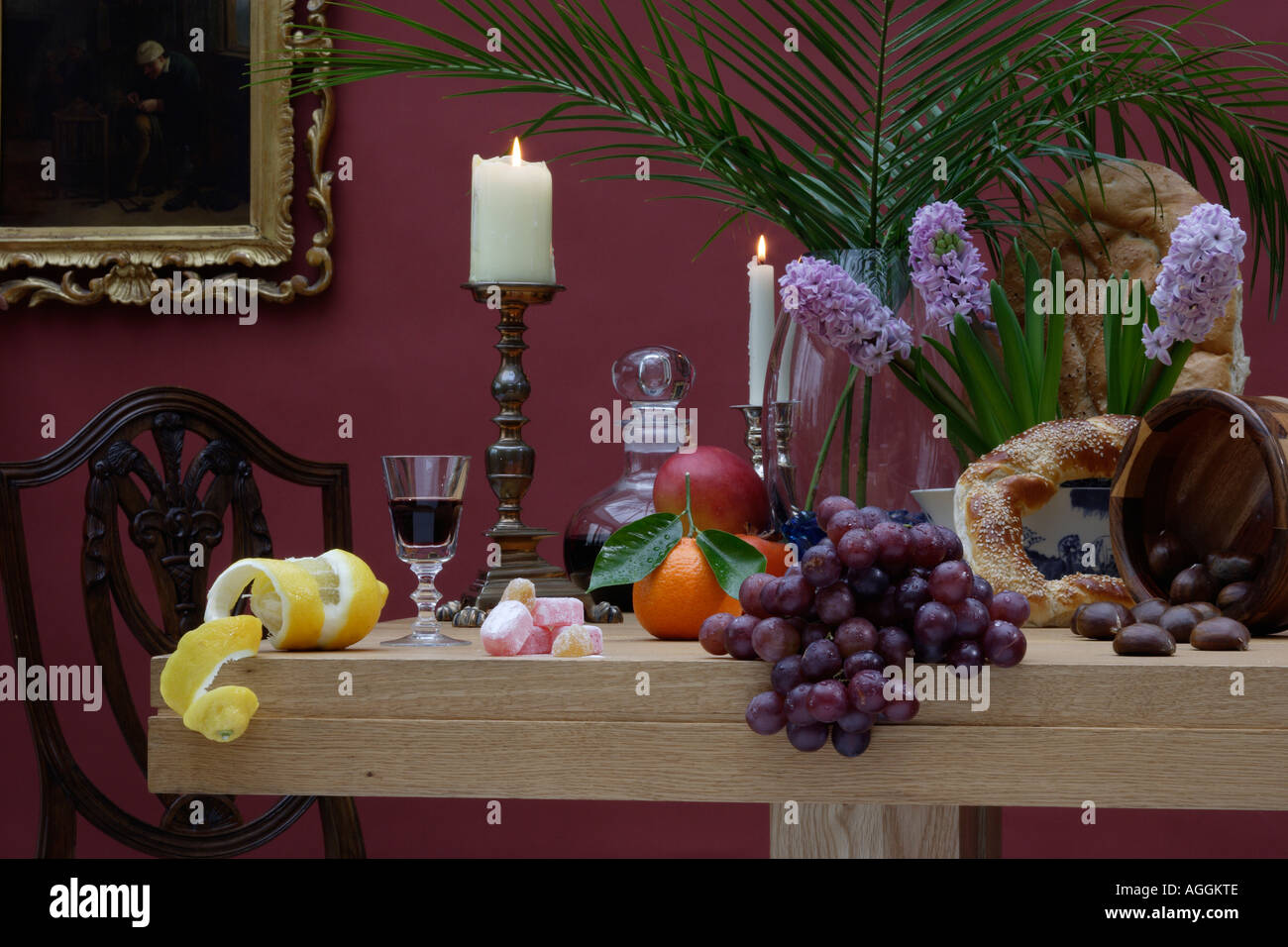 Stillleben mit Obst Brot Blumen und Kerzen auf einer Tischplatte Stockfoto
