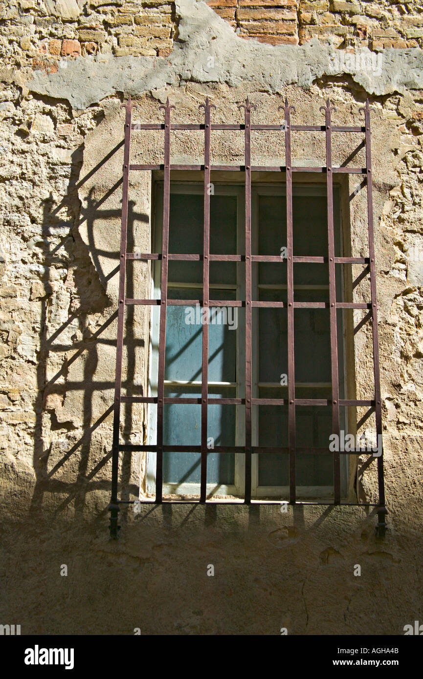 Vergittertes Fenster des Hauses auf die Via San Piero, San Gimignano, Toskana, Italien Stockfoto