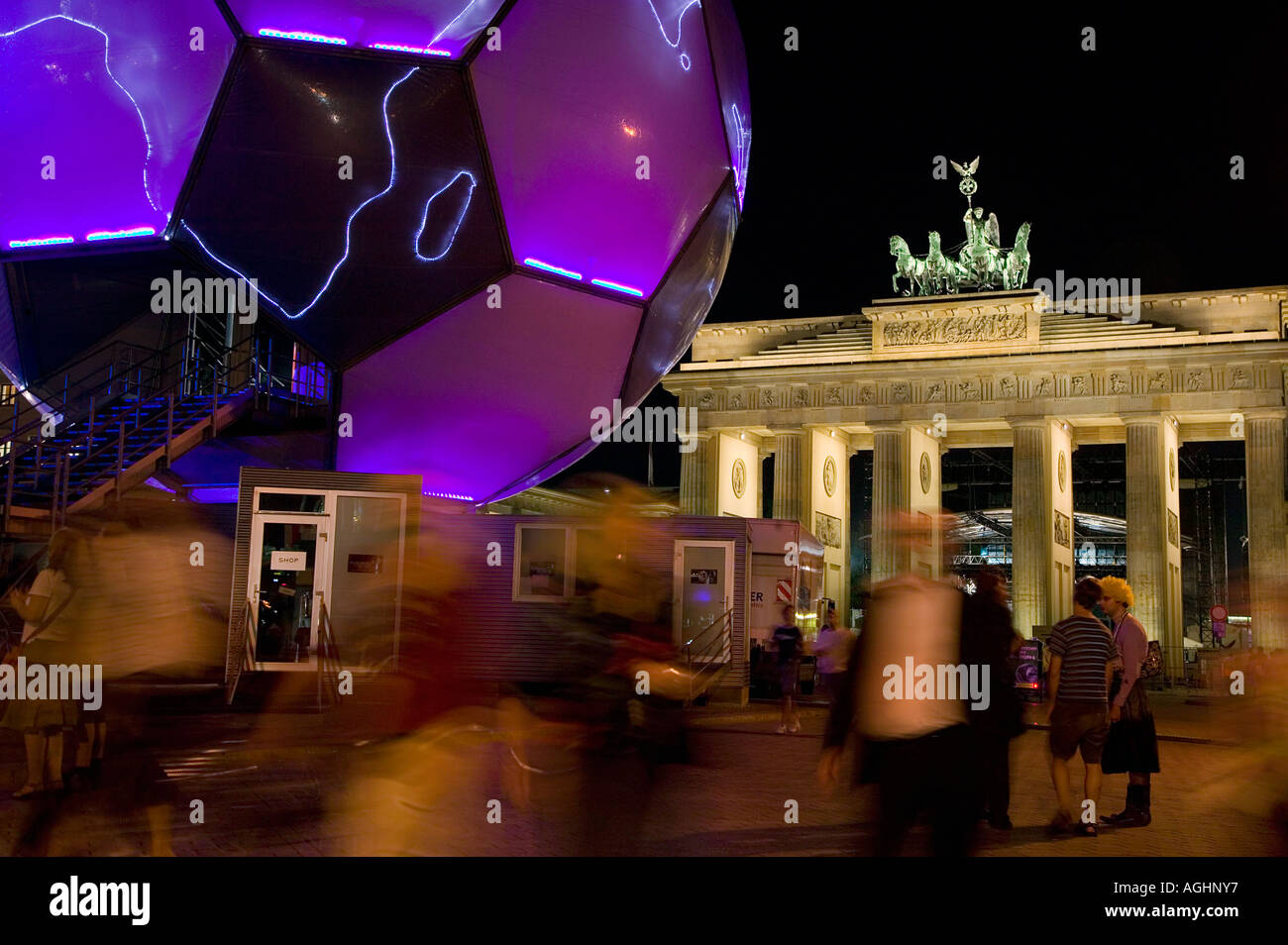 Die Menschen gehen durch eine glühende Fußball-Kugel-Skulptur vor dem Brandenburger Tor während der WM 2006, Berlin, Deutschland Stockfoto
