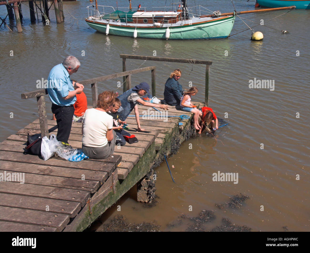 Menschen Angeln für Krabben aus einem kleinen Holzsteg River Deben Woodbridge Suffolk England Stockfoto