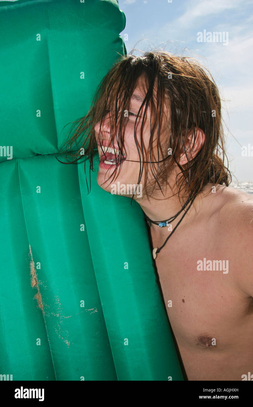 Allein ein junger Mann im Urlaub hat Spaß im Wasser und mit grüner aufblasbarer Liege kaukasischer Hi-res Stockfoto