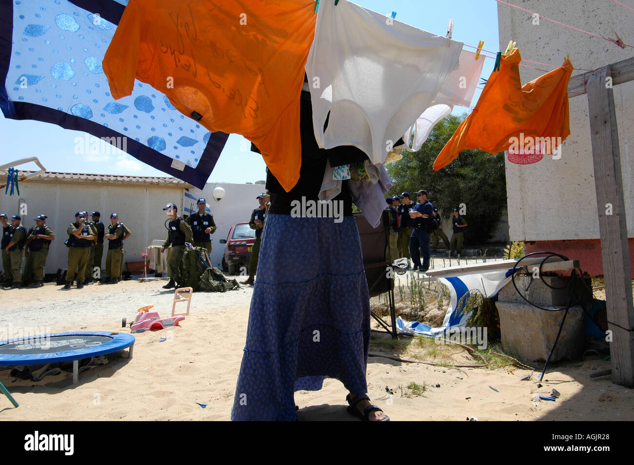 Ein Siedler hängt Wäsche als israelische Soldaten warten, die Siedler aus Tel Katifa jüdische Siedlung als Teil der israelischen Rückzug aus dem Gazastreifen zu entfernen. Stockfoto
