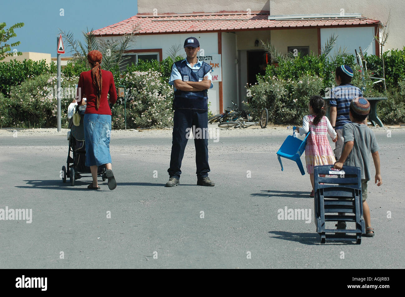 Ein israelischer Polizist beobachtet, wie jüdische Siedler ihr Haus in der Siedlung Tel Katifa verlassen, als Teil des israelischen Abzuckens aus dem Gazastreifen Stockfoto