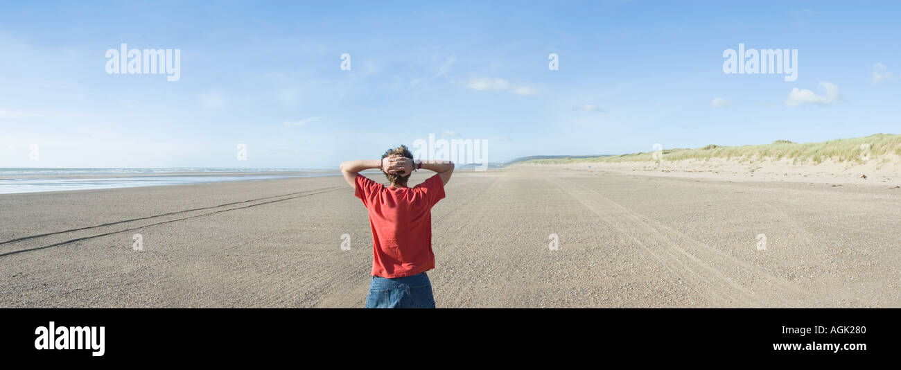 Junger Mann, Blick auf das Meer Saunton Sands Devon UK Stockfoto