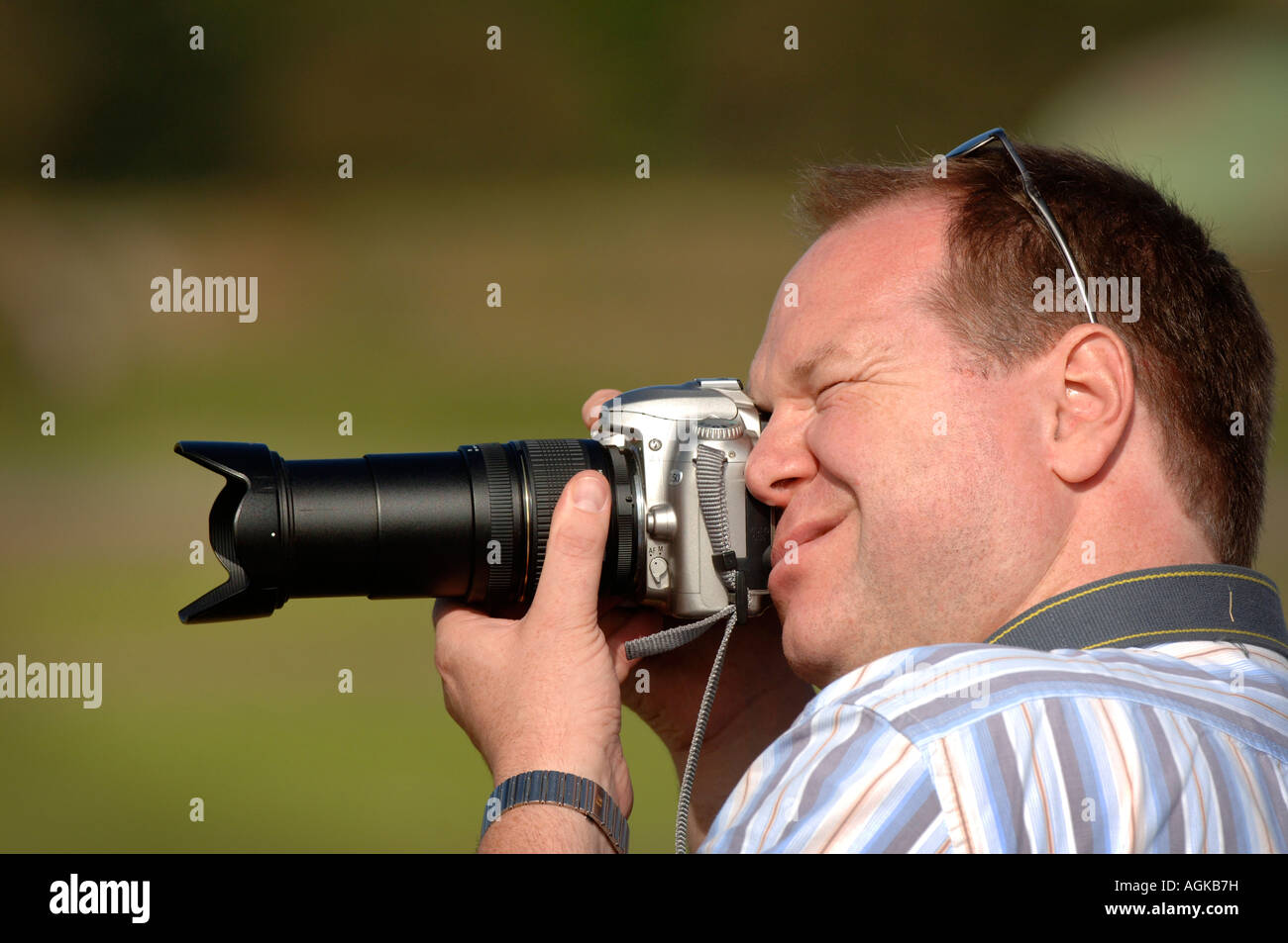 Ein Amateurfotograf mit Nikon-Kamera faltet sein Gesicht für die alles wichtige Aufnahme. Stockfoto