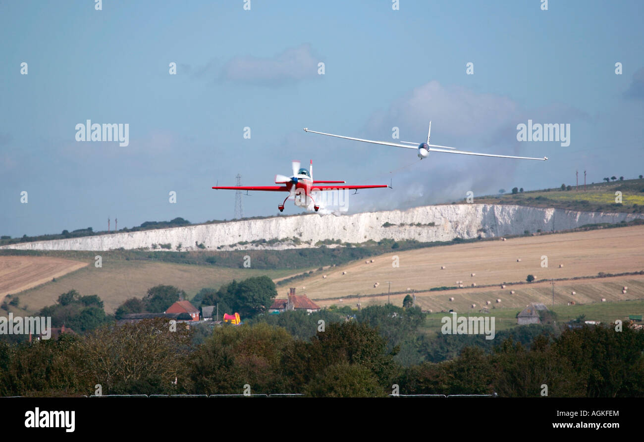 S-1 Swift Glider und Extra 300L Schleppflugzeug, die Kunstflugmanöver auf Shoreham Airshow, Shoreham Airport, West Sussex, england, Großbritannien durchführen Stockfoto