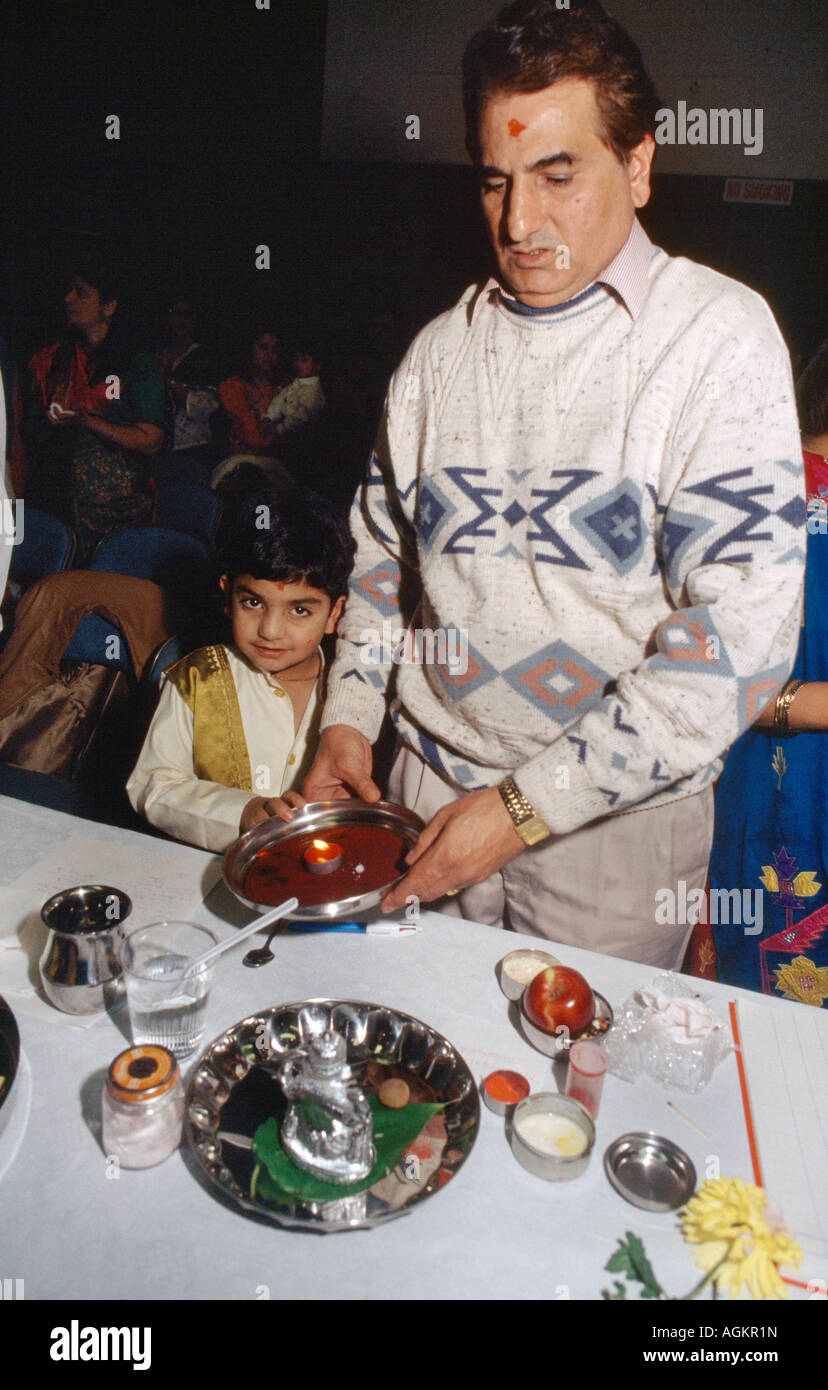 Vater und Sohn halten Diya über Red Chopdis, die Chopda Puja während der Diwali-Aufführung durchführen, was den Beginn des neuen Finanzjahres im Hindu-Kalender bedeutet Stockfoto