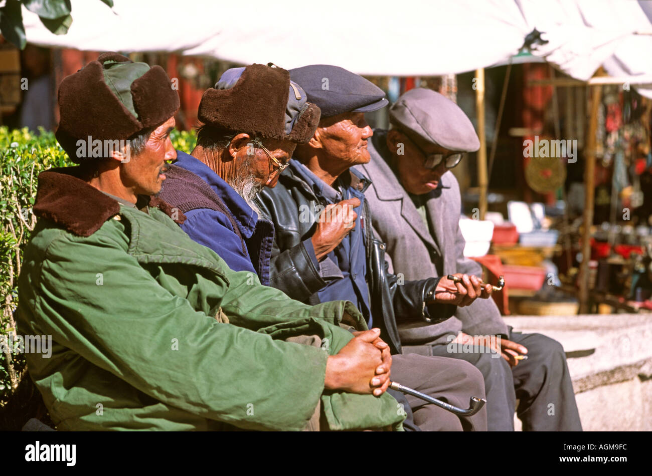 China Yunnan Lijiang alte Stadt alten Naxi Männer sitzen in der Sonne Stockfoto