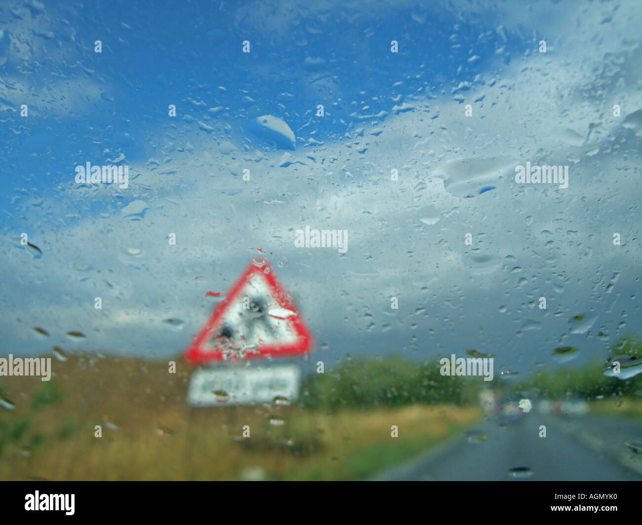 Regen Sie auf der Windschutzscheibe während der Fahrt durch ein Sommergewitter, Baustellen-Schilder Stockfoto