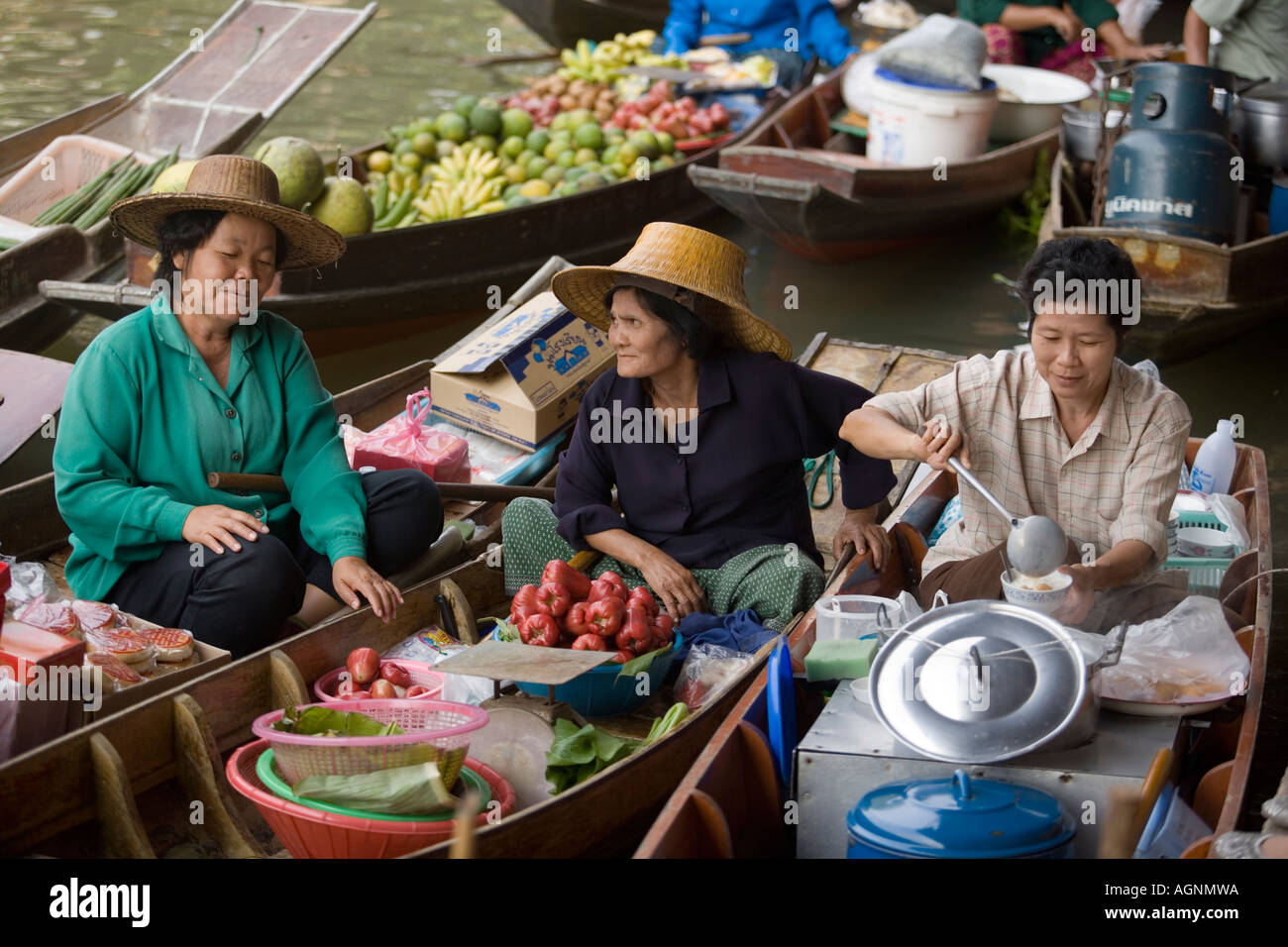 Lachende Marktfrau hält eine Gericht ein weiteres beobachten ihre schwimmenden Markt Damnoen Saduak in der Nähe von Bangkok-Ratchaburi, Thailand Stockfoto