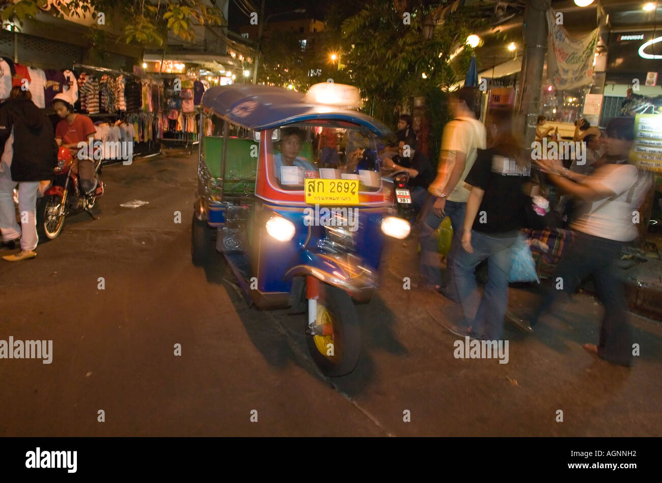 Tuk Tuk vorbei Th Khao San Road in Banglamphu Bangkok Thailand abends Stockfoto