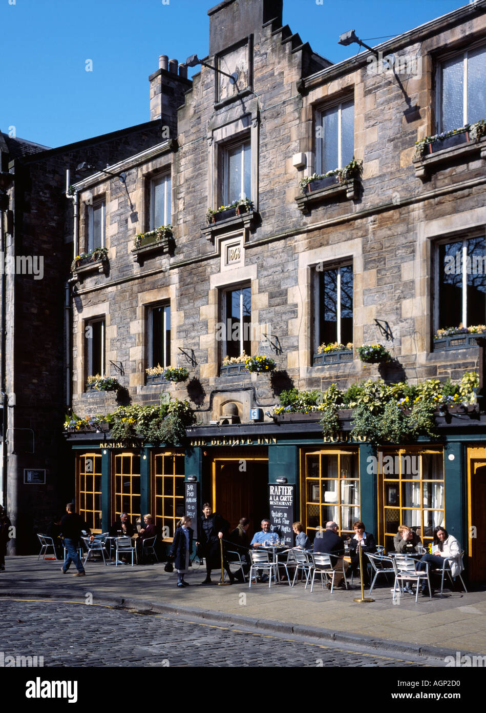 Menschen trinken an Sitzgelegenheiten außerhalb der Bienenstock-Pub in der beliebtes Touristenziel der Grassmarket Gegend von Edinburgh. Stockfoto