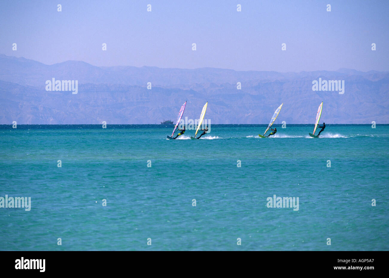 Vier kleine erscheinen, wie sie schnell, weit draußen am Roten Meer Sinai Ägypten Segeln Windsurfer Stockfoto