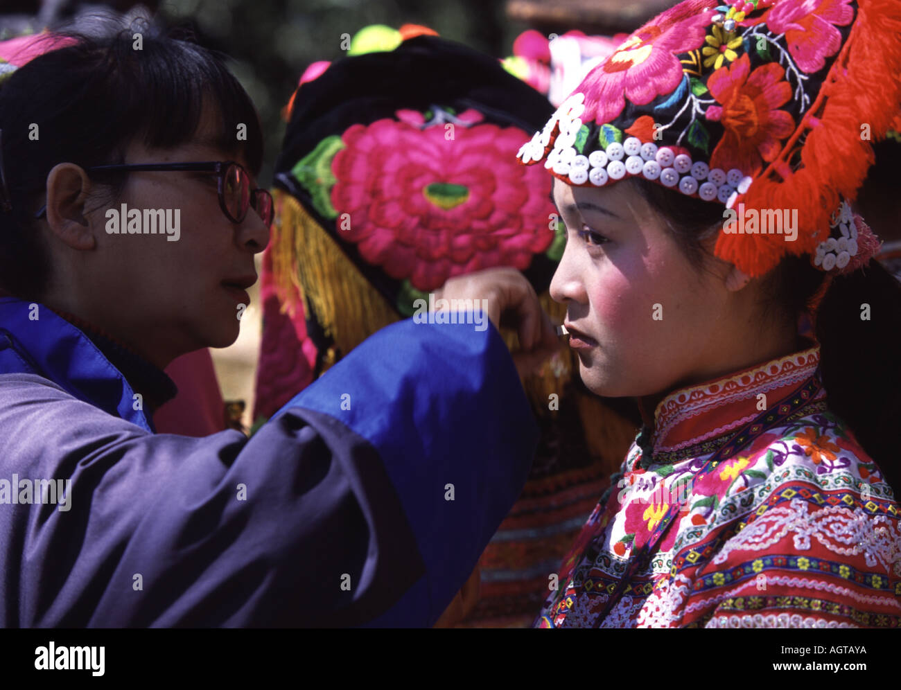 Frau Yi Tanhua, Yunnan, Dressing für das jährliche Blumenfest Pinning Stockfoto