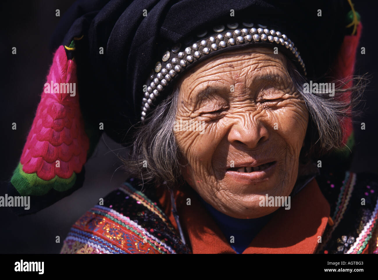 Ältere Yi Frau in Tanhua, Yunnan an das jährliche Blumenfest Pinning Stockfoto