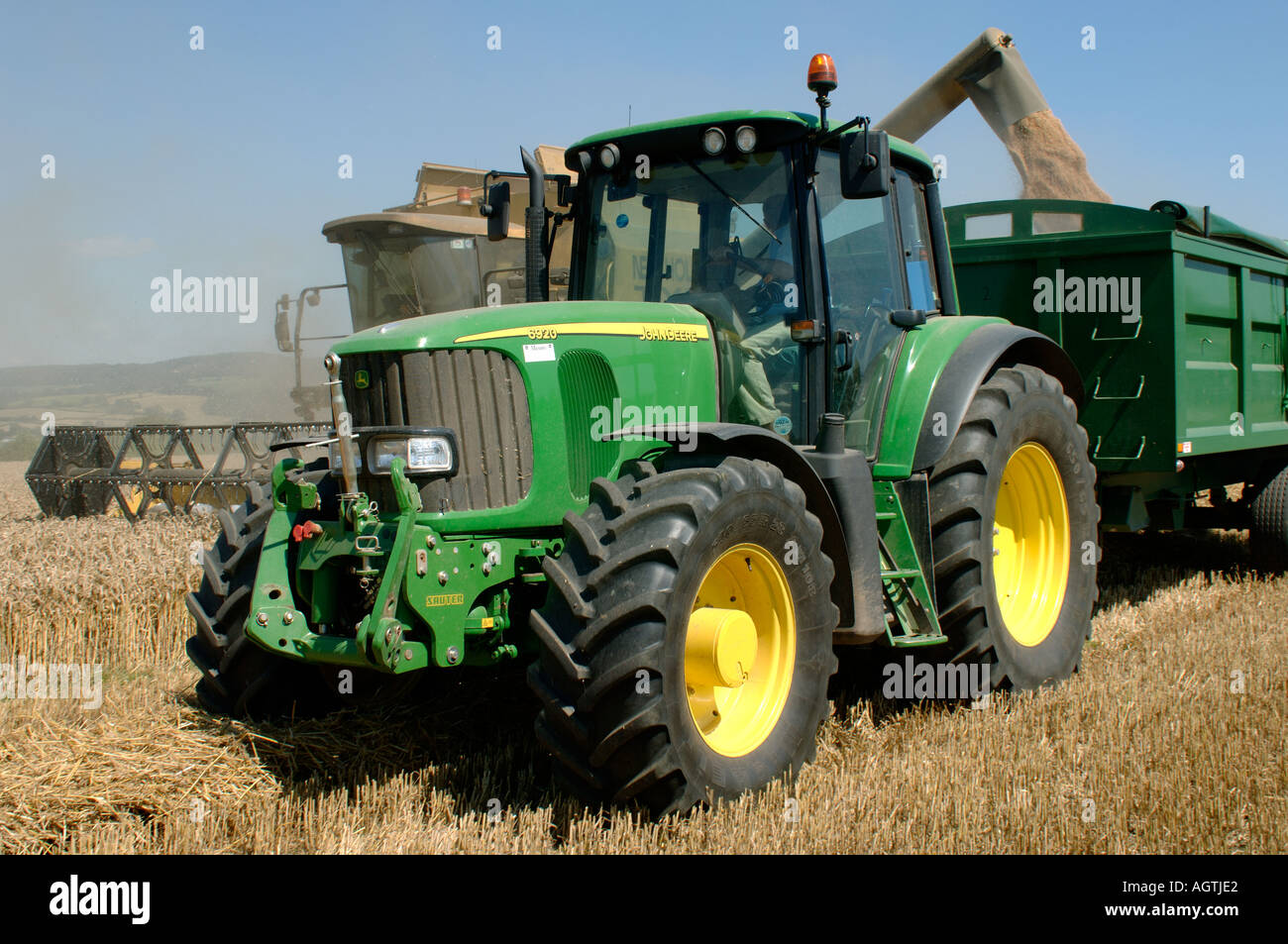 John Deere Traktoranhänger und New Holland TX68 plus kombinieren Ernte reif  Weizen Ernte entladen Stockfotografie - Alamy