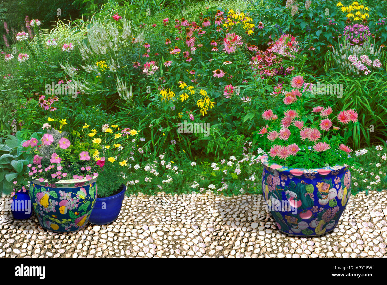 Weißen gepflasterten Terrasse mit großen orientalischen Keramik Töpfe mit Farben der Wildblumen Garten rosa weiß und gelb Stockfoto