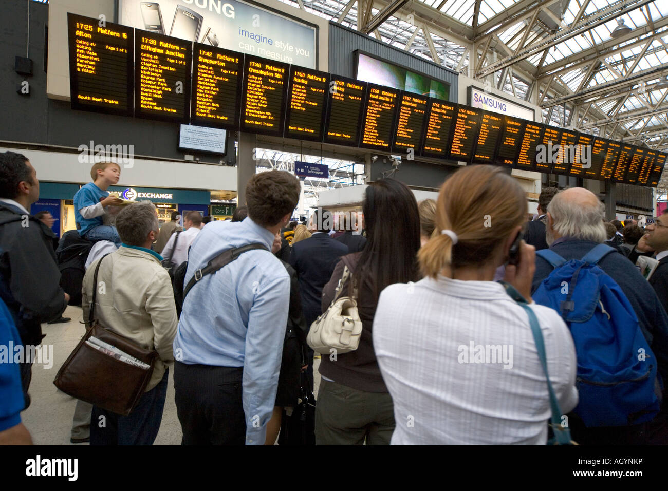 Pendler verzögert im Abfertigungsbereich beobachten Fahrplan an der Waterloo Station-London Stockfoto