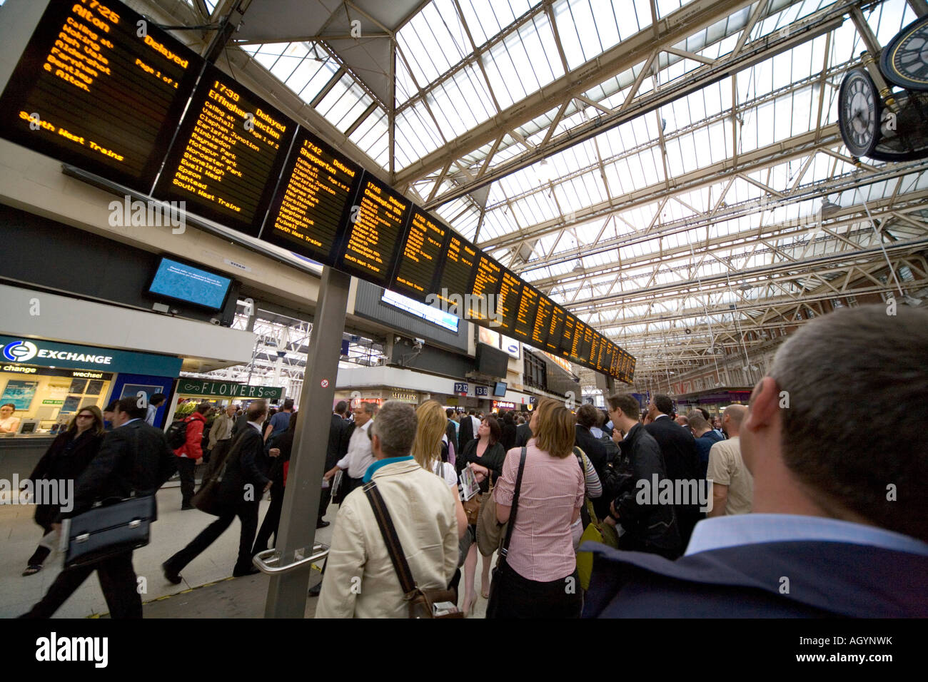 Pendler verzögert im Abfertigungsbereich beobachten Fahrplan an der Waterloo Station-London Stockfoto