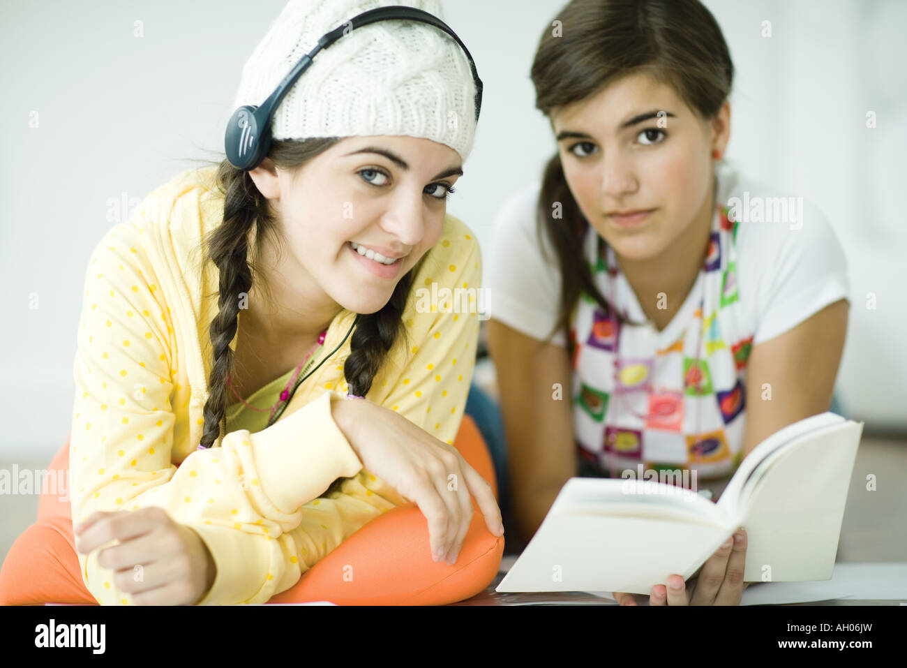 Zwei junge Freundinnen auf Boden liegend, Hausaufgaben zusammen Stockfoto