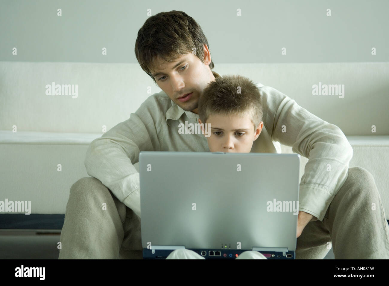 Junge und Laptop zusammen mit Vater Stockfoto